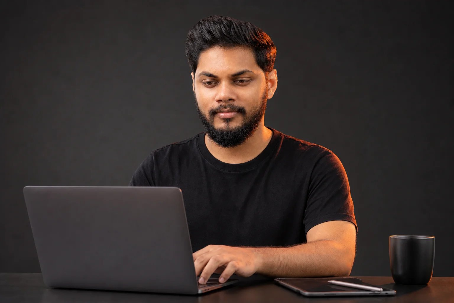 Hesadu Dissanayaka working on a laptop at Hesadu Creatives